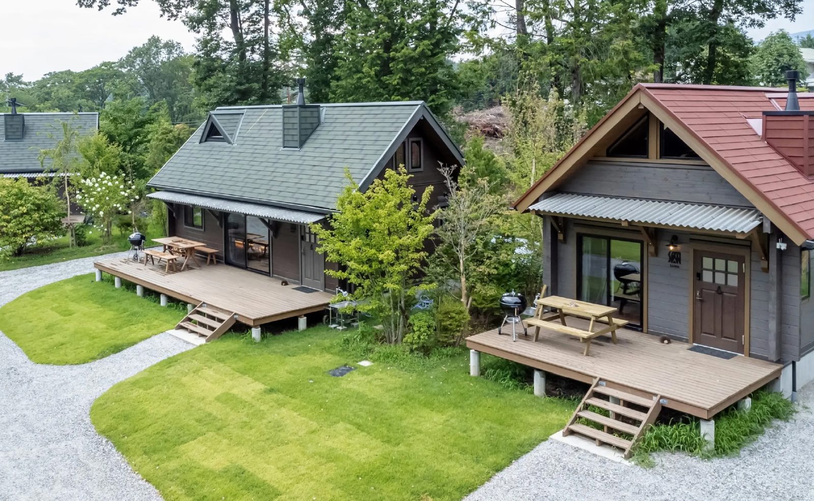 一棟貸しリゾート「kobuchisawa SEKKI」の外観。木立の中に栖ログ3棟が建つ